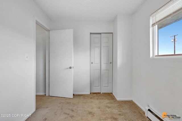 525 E 14th Ave, Anchorage, AK 99501 - unfurnished bedroom featuring carpet flooring, baseboard heating, a closet, and a textured ceiling