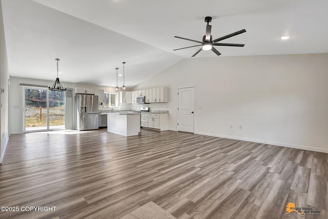 unfurnished living room featuring lofted ceiling, a ceiling fan, wood finished floors, recessed lighting, and baseboards