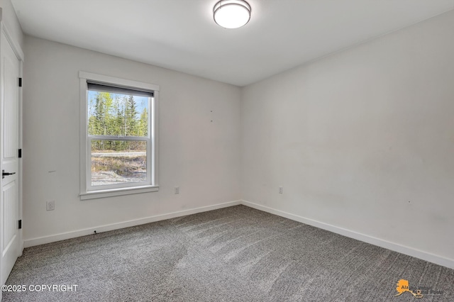 carpeted spare room featuring baseboards