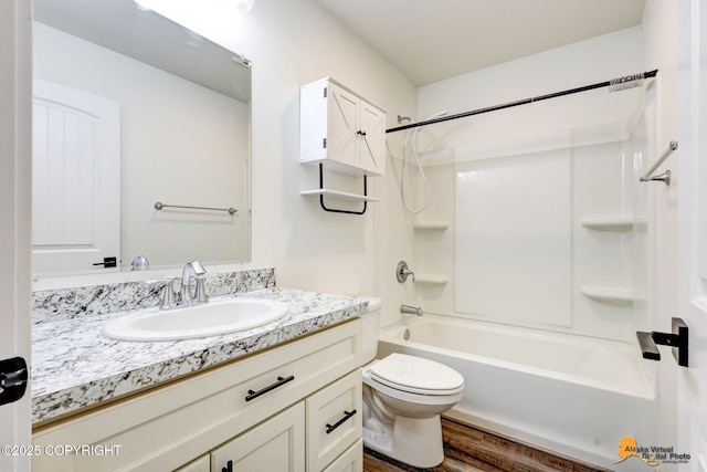 bathroom with wood finished floors, vanity, toilet, and washtub / shower combination