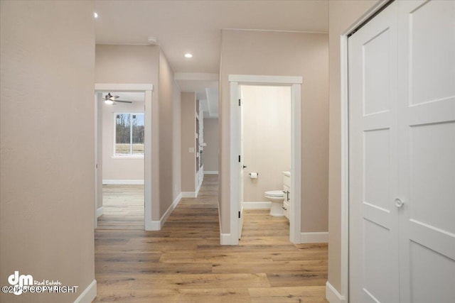corridor featuring recessed lighting, light wood-style flooring, and baseboards