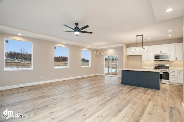 kitchen with recessed lighting, light wood finished floors, white cabinets, and appliances with stainless steel finishes