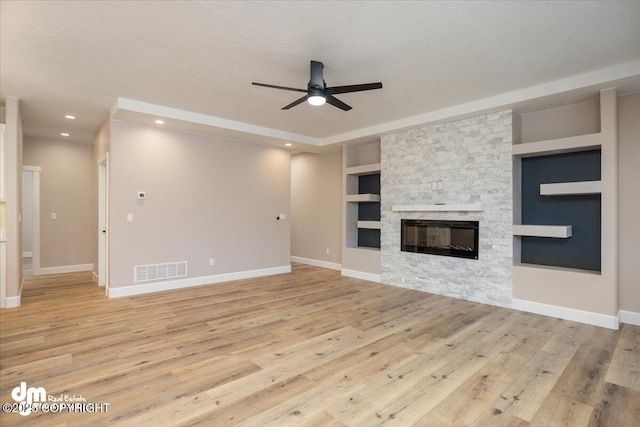 unfurnished living room featuring visible vents, ceiling fan, and light wood-style floors