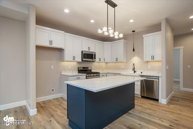 kitchen with white cabinetry, stainless steel appliances, and light wood finished floors