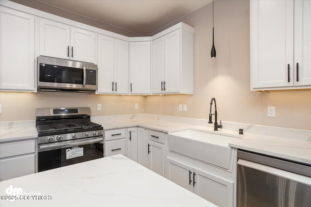 kitchen featuring stainless steel appliances, white cabinets, and a sink