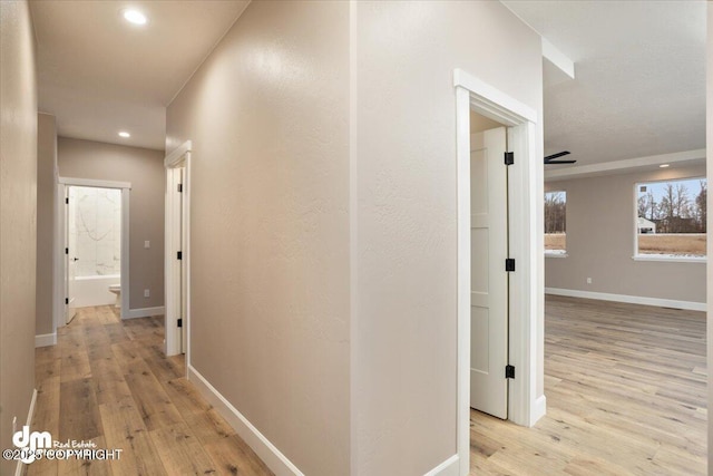 corridor with recessed lighting, baseboards, and light wood-type flooring