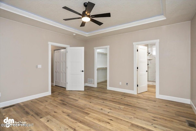 unfurnished bedroom featuring ornamental molding, visible vents, baseboards, and light wood-style floors