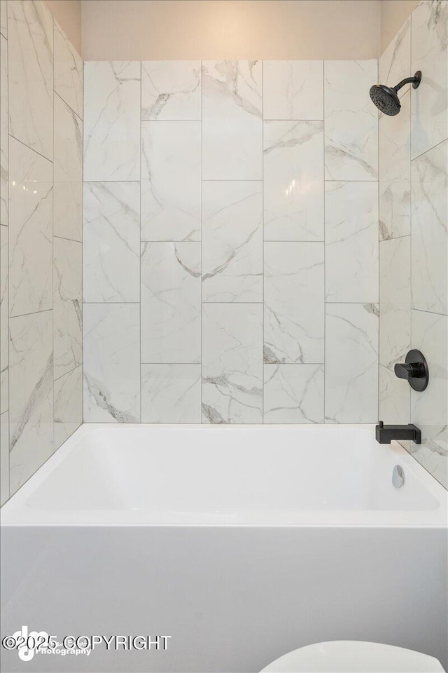 bathroom featuring toilet and  shower combination