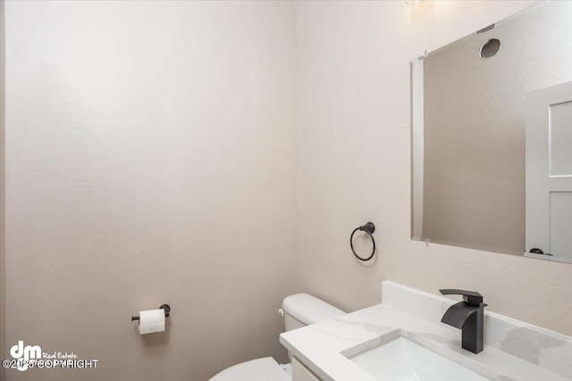 half bath featuring toilet and vanity