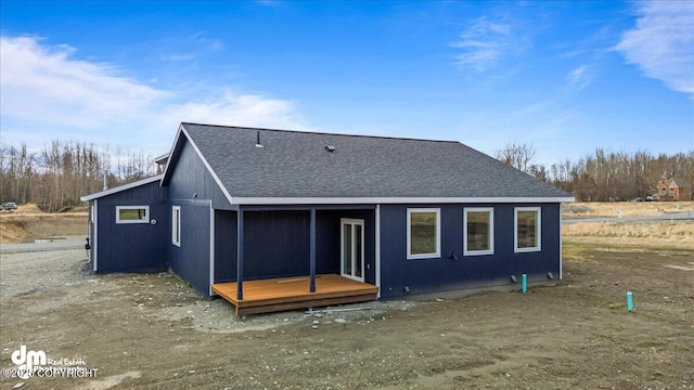 rear view of house featuring roof with shingles