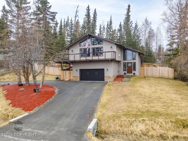view of front of property with a garage, fence, driveway, and stone siding