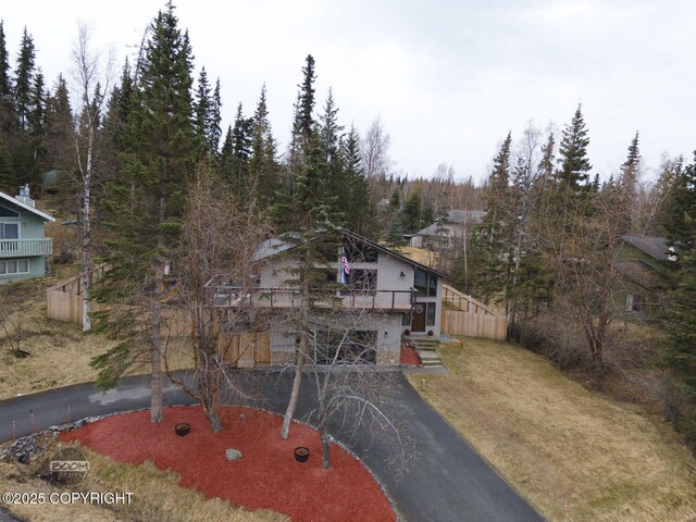 view of front facade with driveway, a wooded view, and stairs