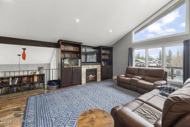 living room featuring beam ceiling, high vaulted ceiling, a stone fireplace, recessed lighting, and wood finished floors