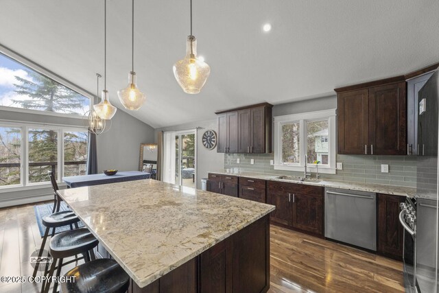 kitchen with backsplash, appliances with stainless steel finishes, dark wood-style floors, and vaulted ceiling