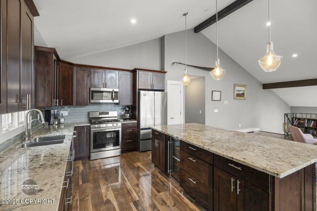 kitchen featuring a kitchen island, beamed ceiling, dark wood-style floors, a sink, and stainless steel appliances