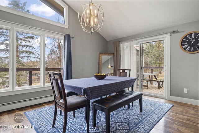 dining area with plenty of natural light, lofted ceiling, a baseboard heating unit, and a chandelier