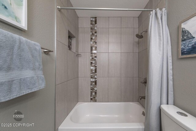 full bath featuring a textured wall, shower / bath combo, and toilet