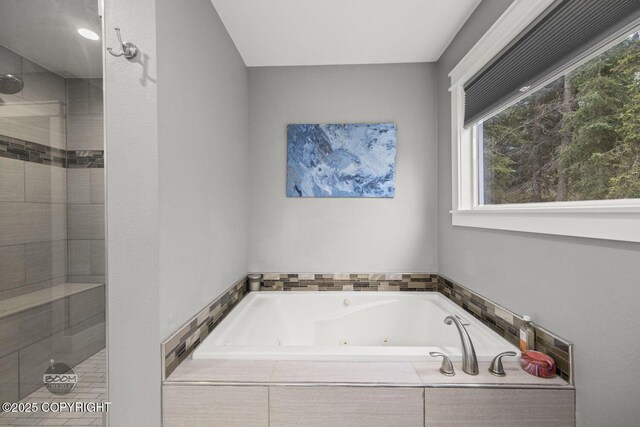 bathroom featuring a whirlpool tub and tiled shower