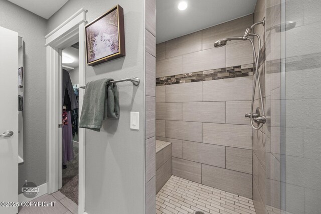 full bathroom with a tile shower and tile patterned flooring