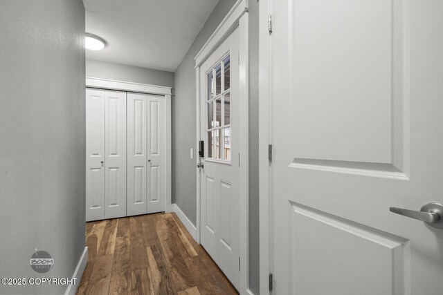 corridor with dark wood-type flooring and baseboards