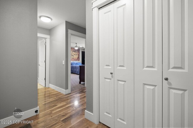 hall featuring baseboards and wood finished floors