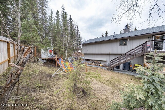 view of yard featuring central AC, fence, a wooden deck, and stairs
