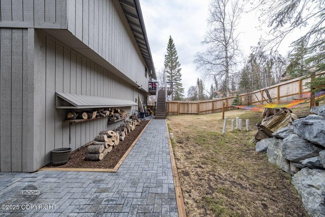 view of yard featuring fence and stairs