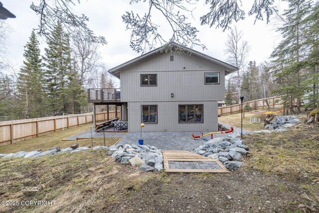 rear view of house with a deck, a fenced backyard, and a patio area