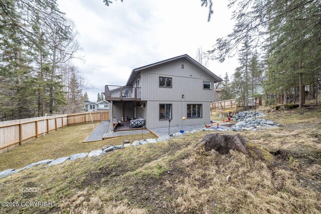 back of property featuring a fenced backyard, a yard, a patio area, and a balcony