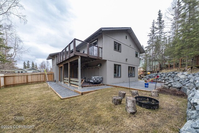 back of property featuring a fenced backyard, a patio, a lawn, and a fire pit