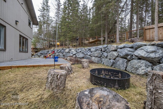 view of yard featuring fence, a patio, and a fire pit
