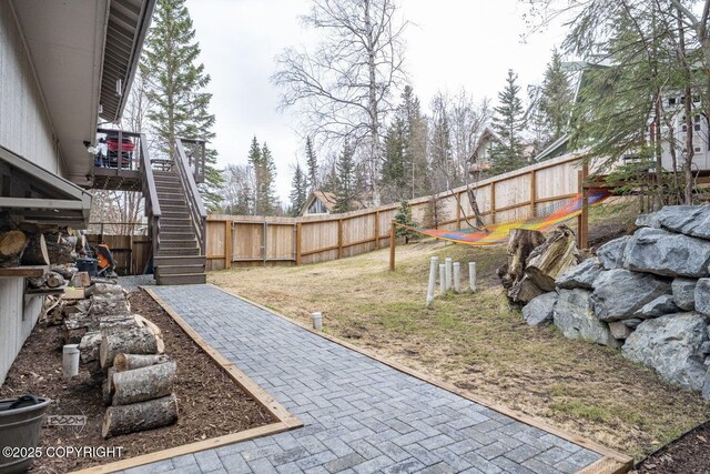 view of yard featuring fence and stairway
