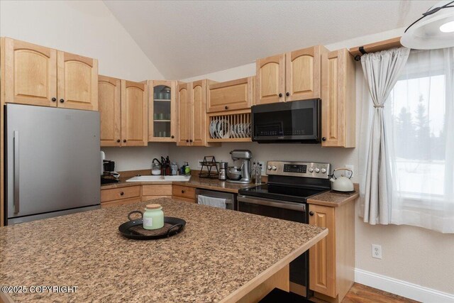 910 Refinery Loop, North Pole, AK 99705 - kitchen featuring vaulted ceiling, glass insert cabinets, stainless steel appliances, a sink, and light brown cabinetry