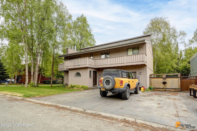 3210 Seawind Dr, Anchorage, AK 99516 - view of front facade featuring a balcony, a chimney, and a gate