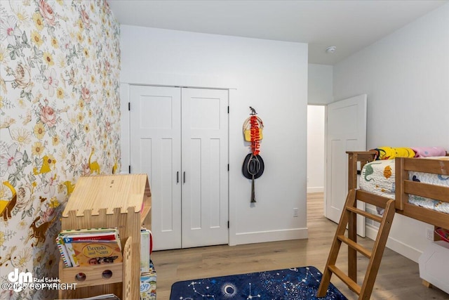 3460 S Shamrock St, Wasilla, AK 99623 - bedroom with wood finished floors, baseboards, wallpapered walls, and a closet