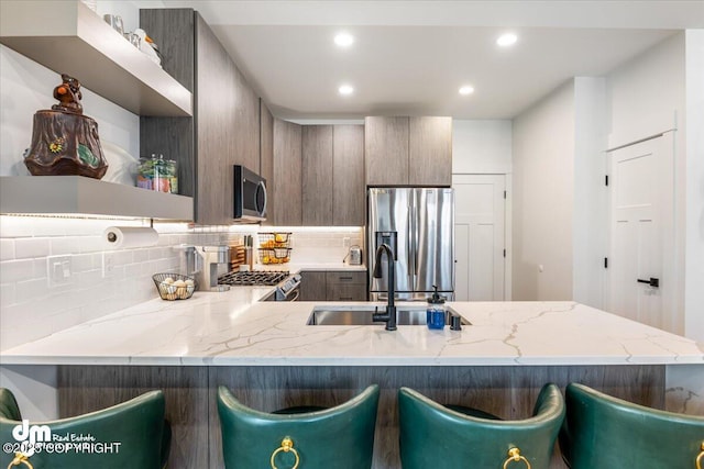 3460 S Shamrock St, Wasilla, AK 99623 - kitchen featuring stainless steel appliances, a sink, recessed lighting, decorative backsplash, and modern cabinets