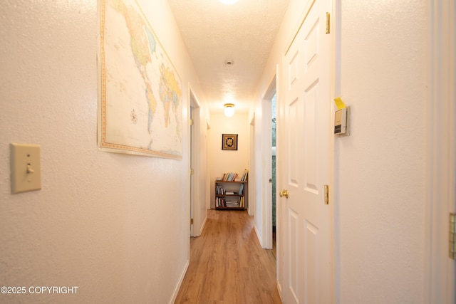 414 Bonanza Ave, Homer, AK 99603 - hall with light wood finished floors, a textured ceiling, and baseboards