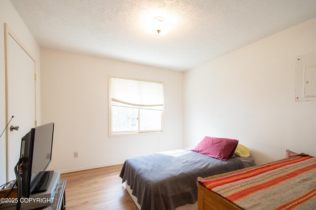 414 Bonanza Ave, Homer, AK 99603 - bedroom featuring wood finished floors, a textured ceiling, and baseboards