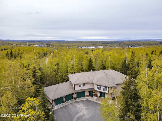 aerial view of property and surrounding area with a forest