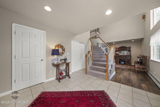 entrance foyer with tile patterned flooring, stairs, baseboards, a baseboard radiator, and recessed lighting
