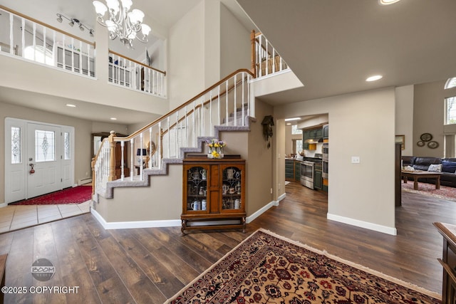 entryway featuring stairs, baseboards, wood finished floors, a high ceiling, and recessed lighting