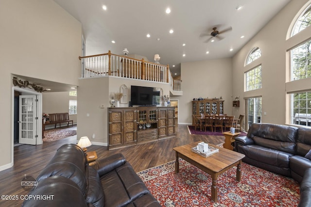 living room featuring a high ceiling, ceiling fan, recessed lighting, wood finished floors, and baseboards