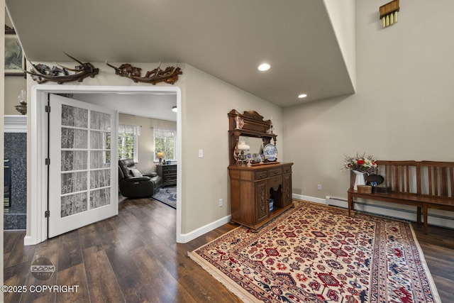 foyer entrance featuring wood finished floors, baseboard heating, recessed lighting, and baseboards