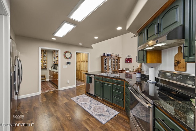 kitchen featuring appliances with stainless steel finishes, green cabinetry, a sink, under cabinet range hood, and recessed lighting