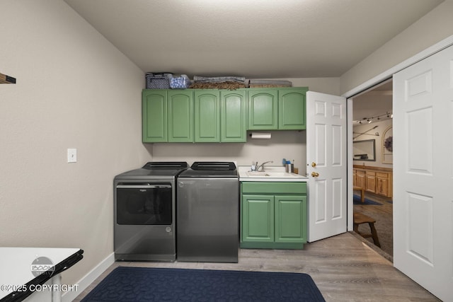 laundry room with cabinet space, washing machine and clothes dryer, light wood finished floors, and baseboards