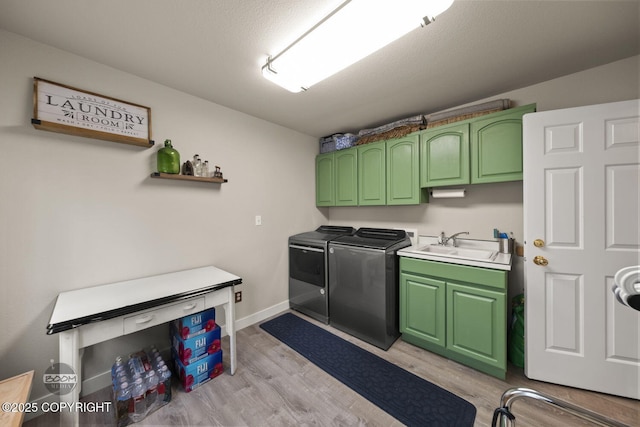 laundry room featuring cabinet space, washer and clothes dryer, and light wood finished floors