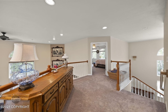 corridor with an upstairs landing, carpet flooring, recessed lighting, and plenty of natural light