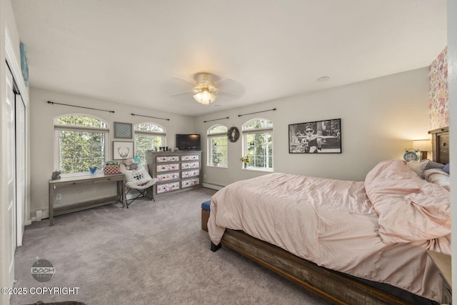 carpeted bedroom with ceiling fan and a baseboard radiator