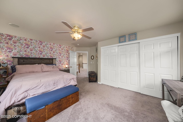 carpeted bedroom featuring a closet, wallpapered walls, and a ceiling fan