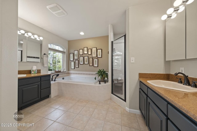 full bathroom featuring a stall shower, a garden tub, tile patterned flooring, and two vanities
